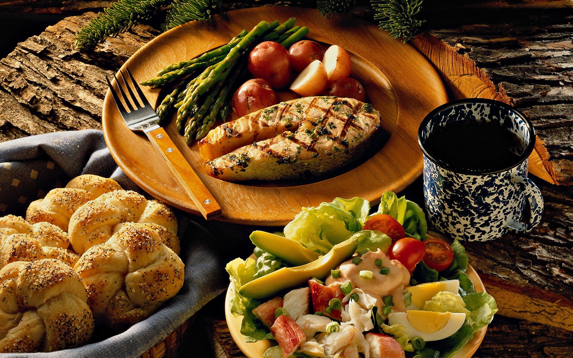 Grilled chicken with asparagus, fresh bread and a garden salad on rustic wood